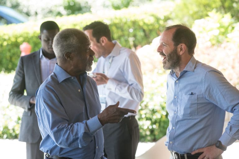 two men standing across from one another talking to each other.
