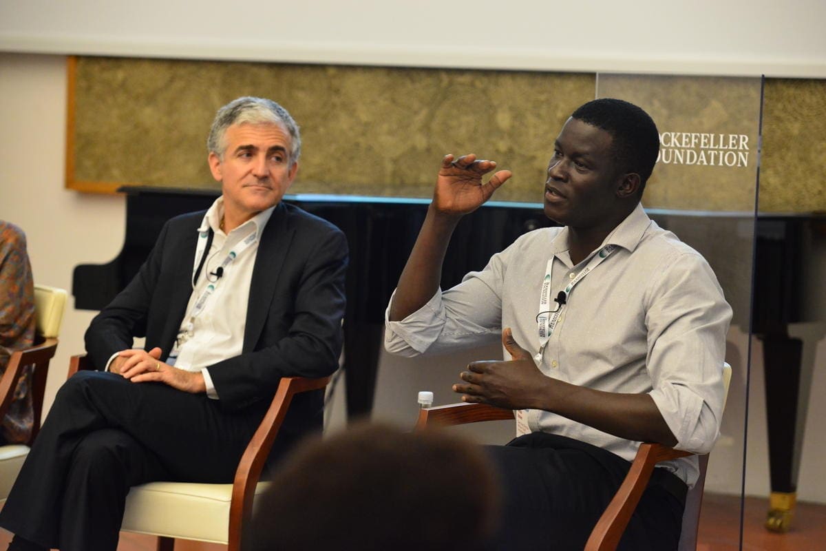 two men sitting in chairs talking.