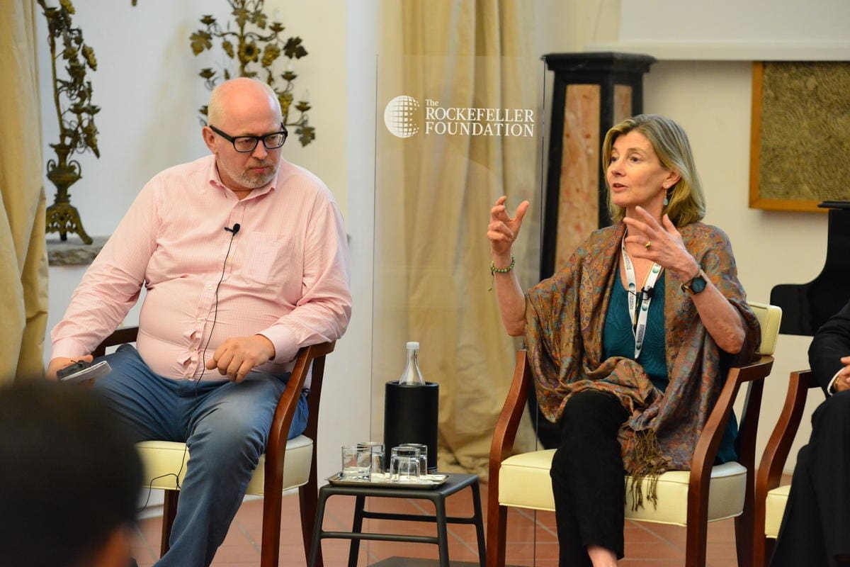 a woman and man sitting in chairs talking.