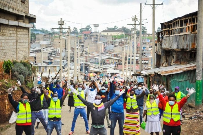 group of people standing on the streets celebrating with both hands and arms up