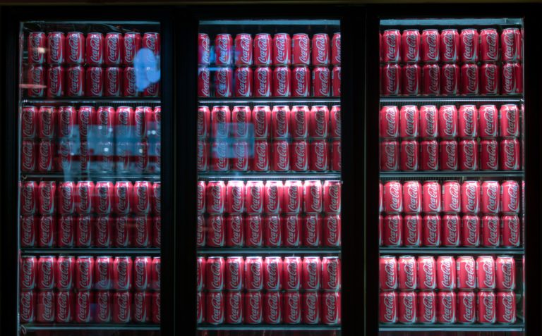 Fridges fully stocked with Coca-Cola.