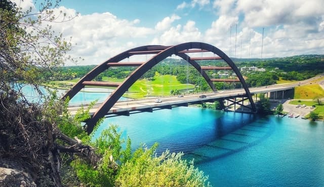 a bridge over a river with blue water