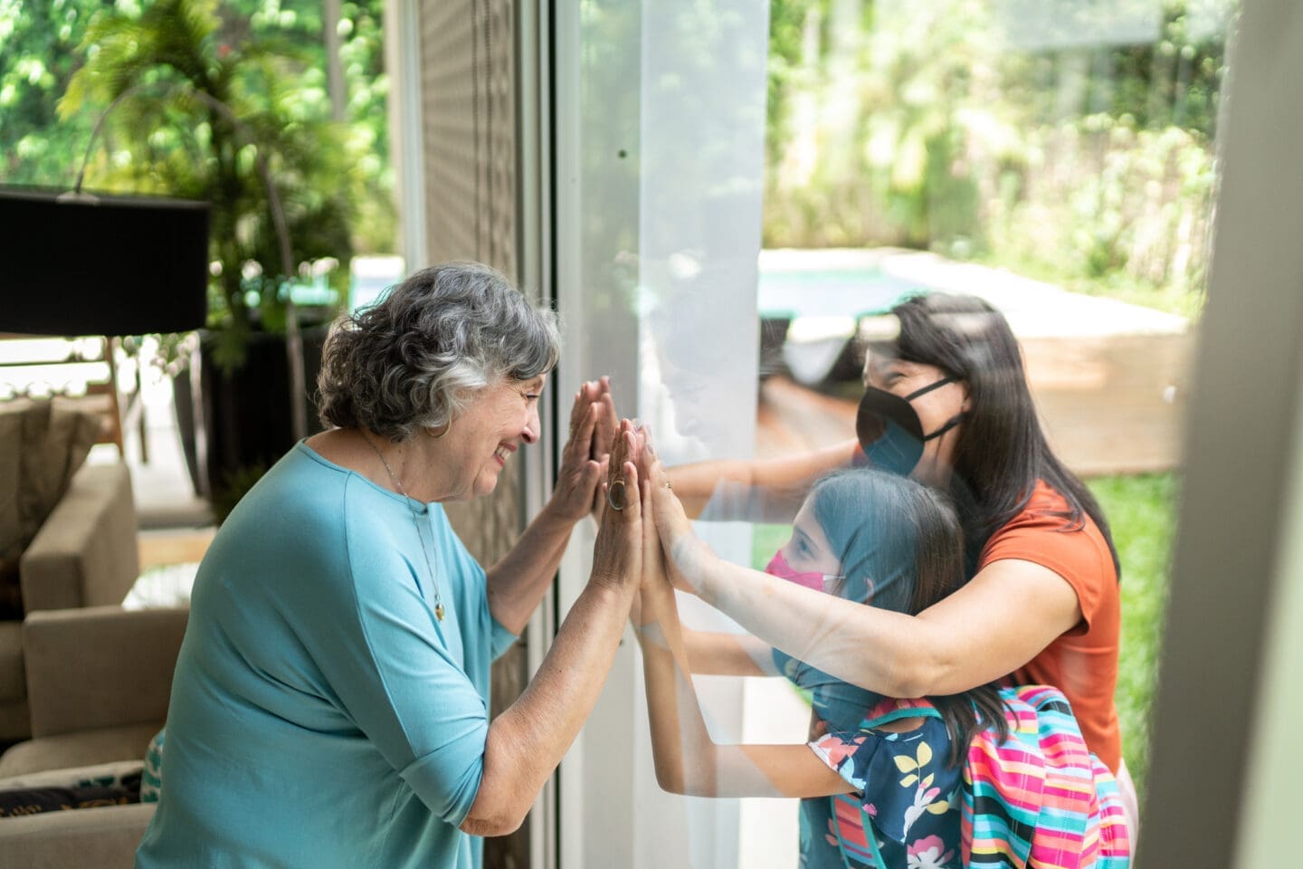 Senior woman being greeted through window during quarantine