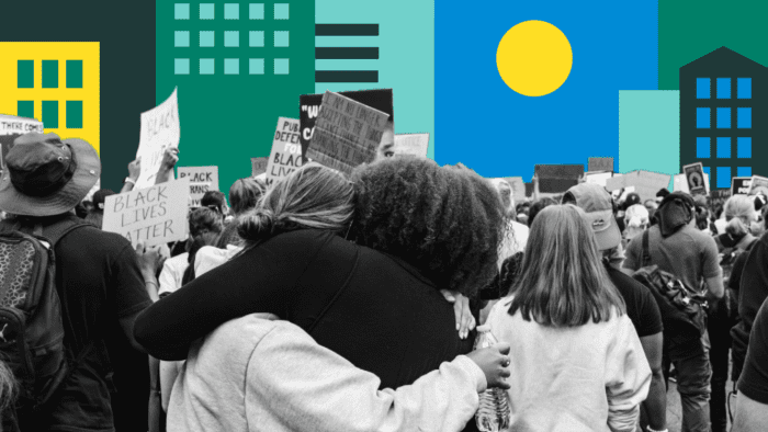 two women hugging each other at a protest.