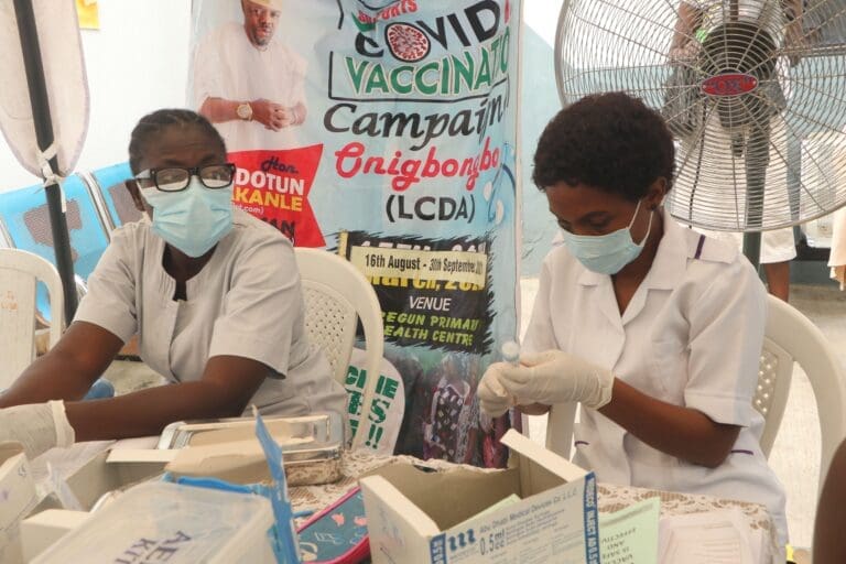 two health workers giving covid-19 vaccines.