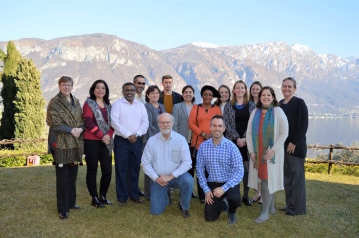 group shot of men and women with mountains in the background.