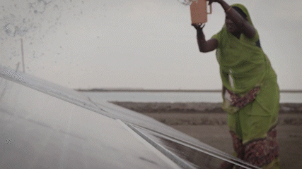 GIF of a woman cleaning a solar panel.
