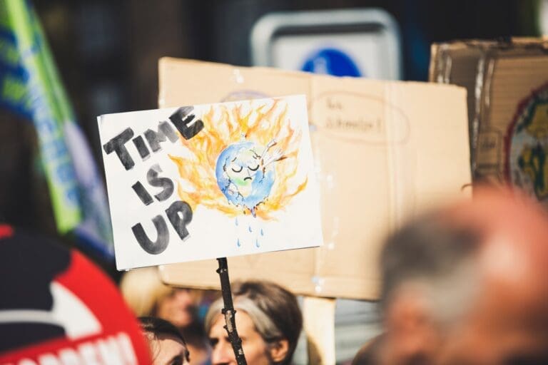 someone holding a sign on a stick that says