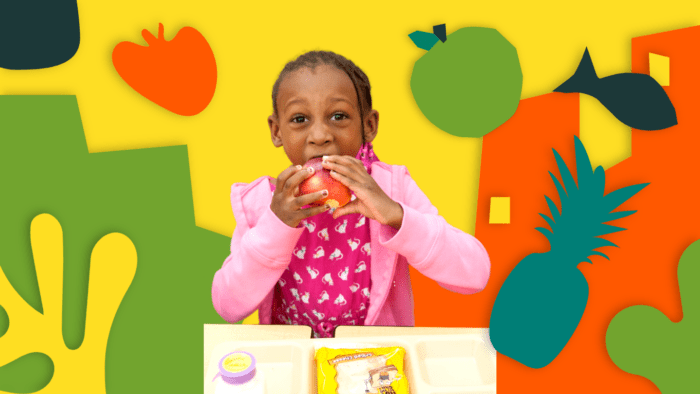 young girl eating an apple at lunch.