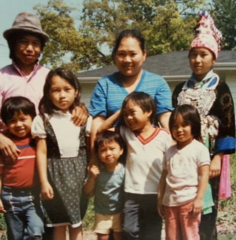 men, women, and children standing and smiling.