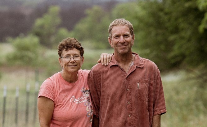 man and woman standing side by side smiling.