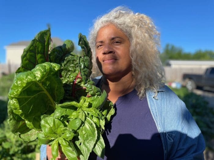 man standing holding lettuce in his arm