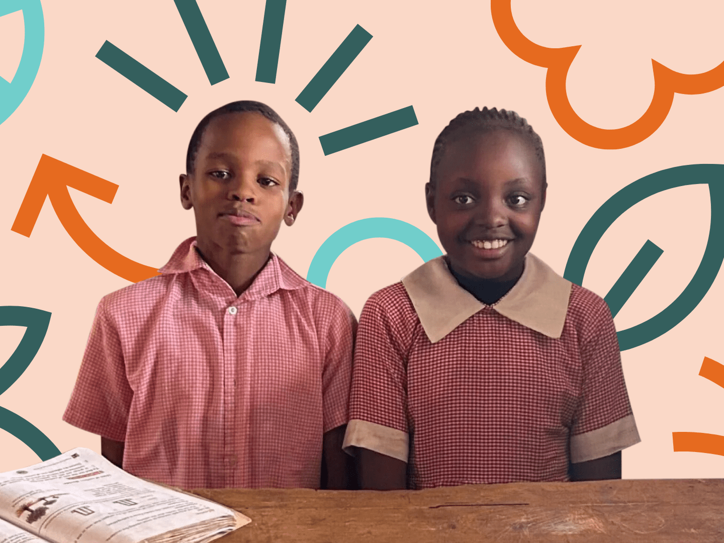 two young girls smiling and sitting at a table at school