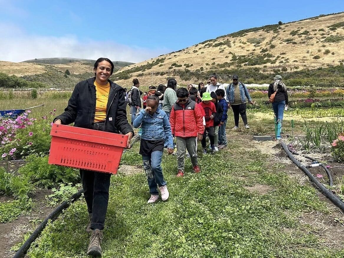 Farmer Zee Husain teaches youth in a summer program how to harvest zucchini (Photo courtesy of Deep Medicine Circle)