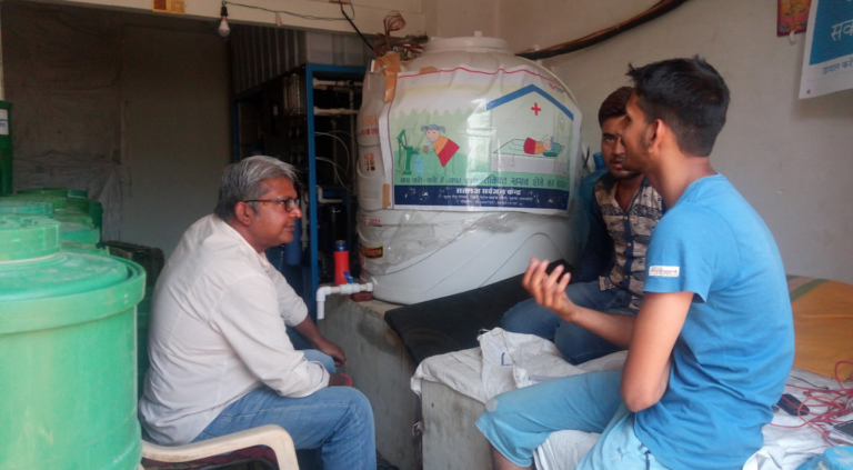 Sami Mitra meets in 2019 with an entrepreneur in Bihar who, because of reliable mini-grid electricity available in his village, has started a water treatment plant. (Photo Courtesy of Sami Mitra)