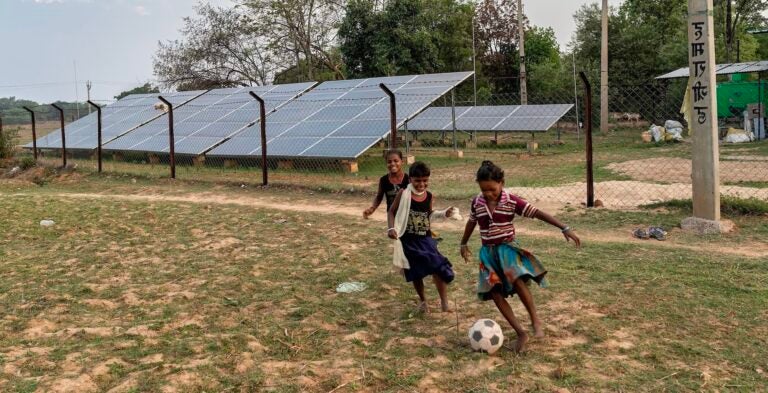children playing soccer near solar panels in rural Jharkhand State in eastern India, 2018