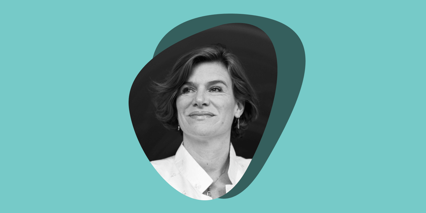 A black and white photo of a woman smiling at the camera in a rounded, triangular frame, set against overlapping teal and turquoise circles on a light teal background