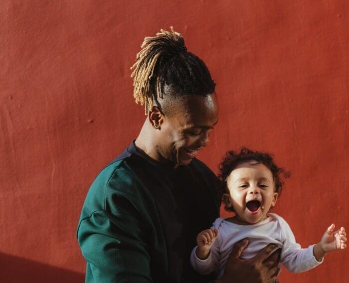 man holding a baby in his arms.
