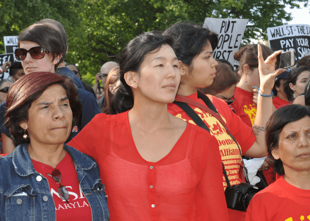 Aj-jen Poo of the National Domestic Workers Alliance standing amongst other protesters.