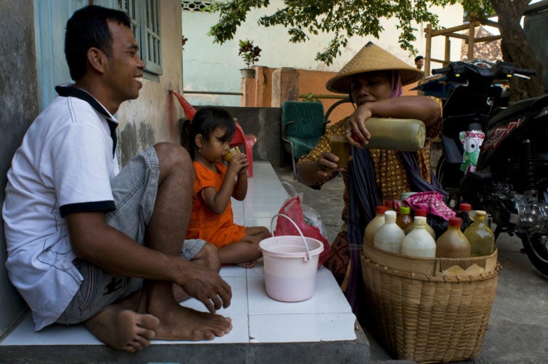Street vendor sells product to a man and child.