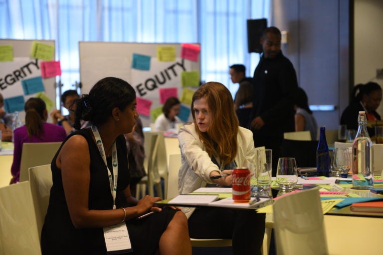 Two female Rockefeller Foundation employees in a discussion at the All Staff event.