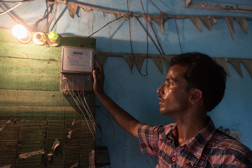 Small business owner checks a meter to see how much electricity he's consumed.