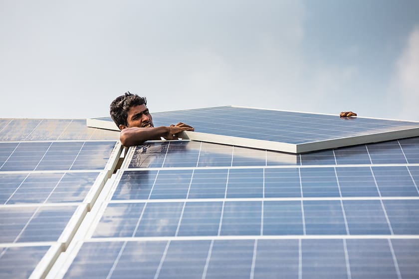 Man installing the final module on a solar panel.