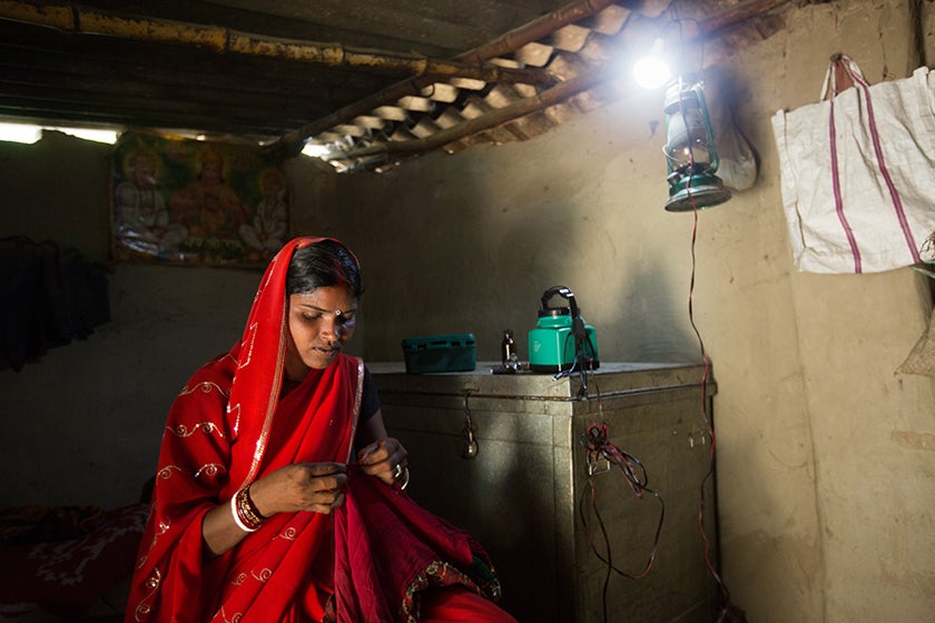 Woman stitching under a smart powered lamp.