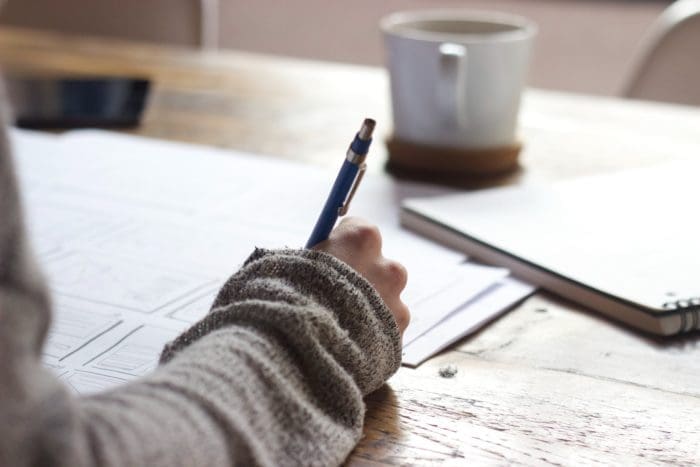 Person drafting a project with a pen.