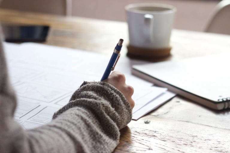 Person drafting a project with a pen.
