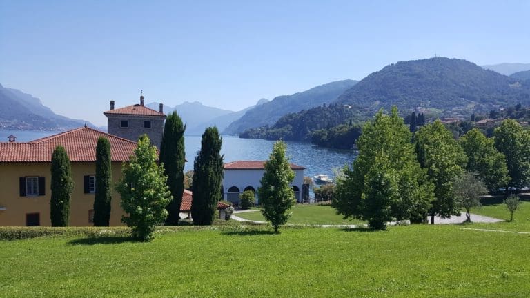 view of trees, a building, mountains and an ocean.