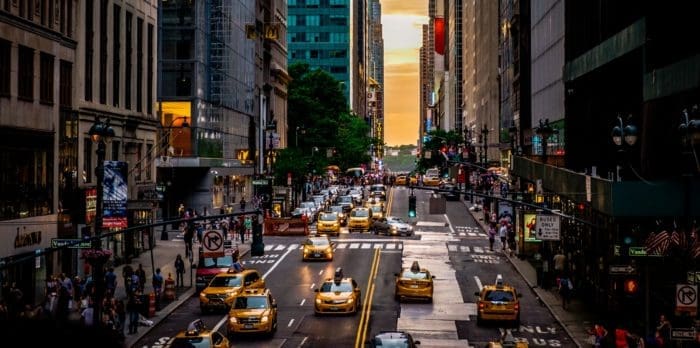 Bustling city street at sunset.