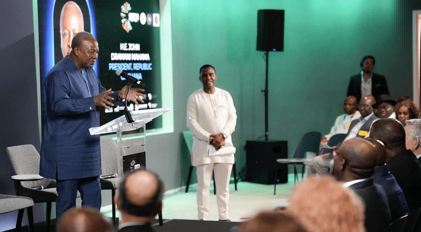 former Ghanaian President John Dramani Mahama speaks at a podium during a Rockefeller Foundation UNGA 2025 event, addressing an audience while a moderator stands nearby.