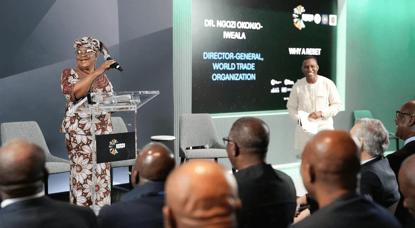 Dr. Ngozi Okonjo-Iweala, Director-General of the World Trade Organization, speaks at a podium during a Rockefeller Foundation UNGA 2025 event, while an audience listens and another moderator smiles nearby.
